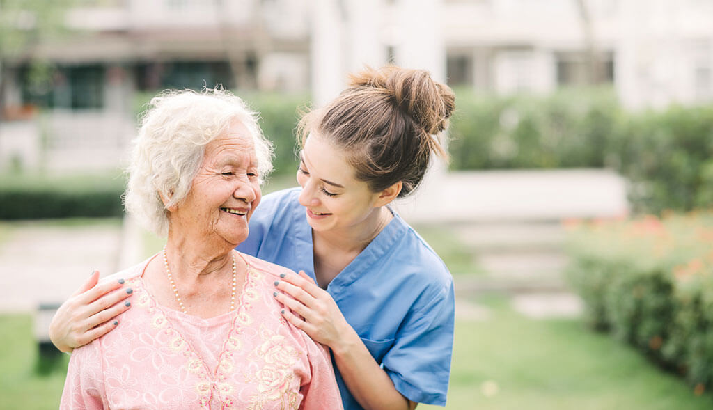 Home healthcare worker assists older woman.